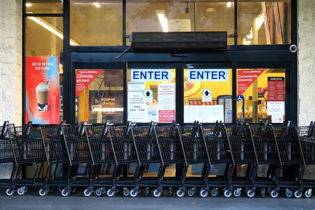 Client examinant son ticket de caisse dans un rayon de supermarché