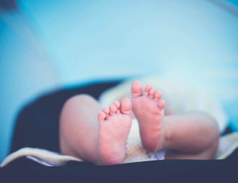 Pieds d'un nouveau-né tenus dans une main