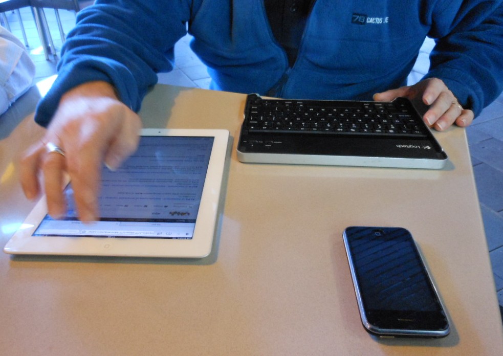 Une personne gère son activité en ligne avec une tablette, un smartphone et un clavier