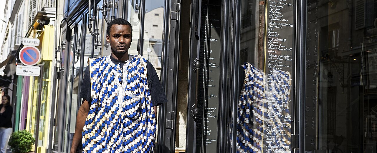 Piéton marchant dans une rue de Paris le long d'un immeuble ancien