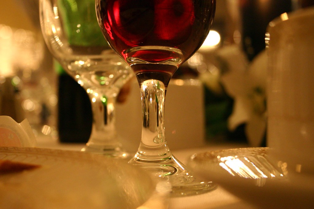 Un verre de vin rouge posé sur une table dressée
