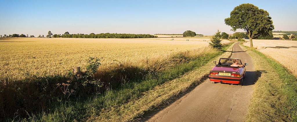 Une voiture circule sur une route de campagne française au petit matin