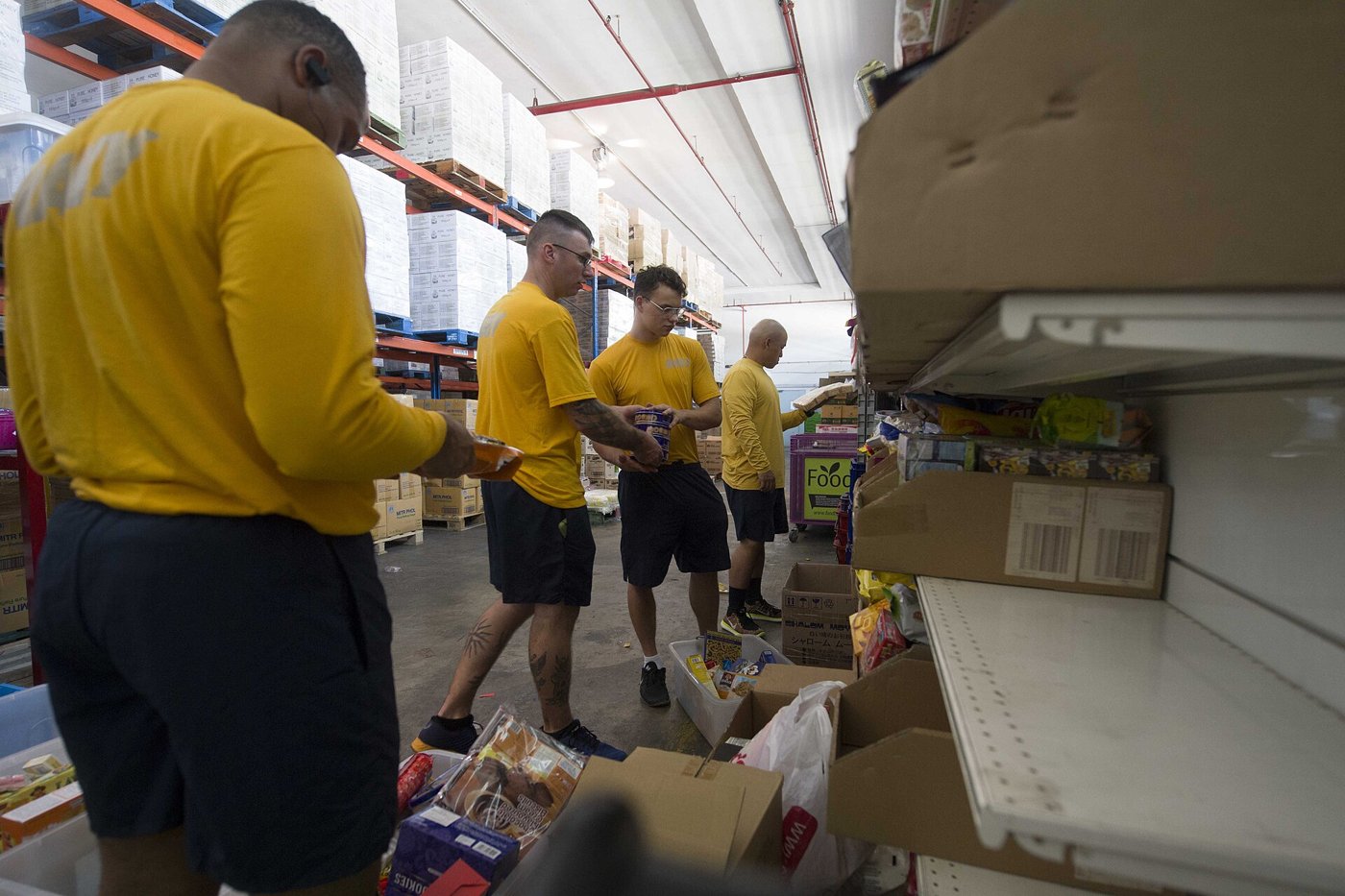 Bénévoles triant et distribuant des denrées dans un local d'aide alimentaire