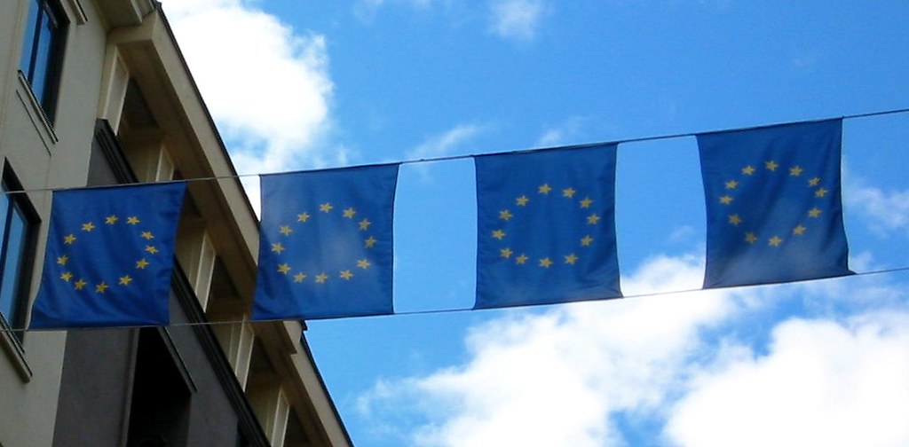 Des drapeaux de l'Union européenne accrochés à la façade d'un bâtiment