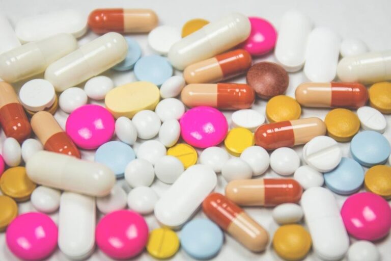 Boîtes de médicaments et plaquettes de comprimés sur un rayon de pharmacie
