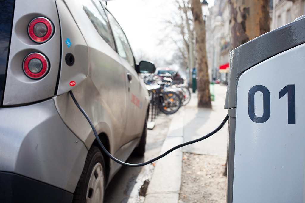 Voiture électrique branchée à une borne de recharge dans une rue résidentielle