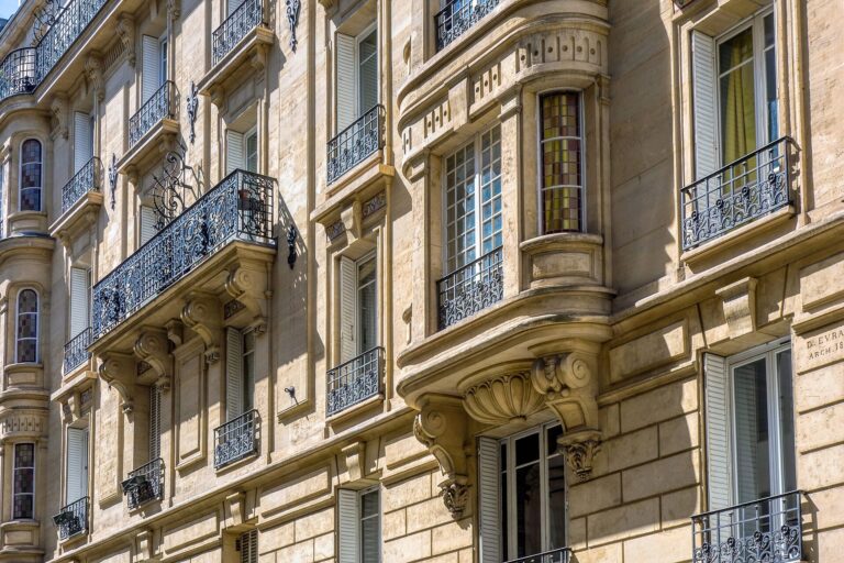Façade d’un immeuble haussmannien avec balcons en fer forgé dans une grande ville française