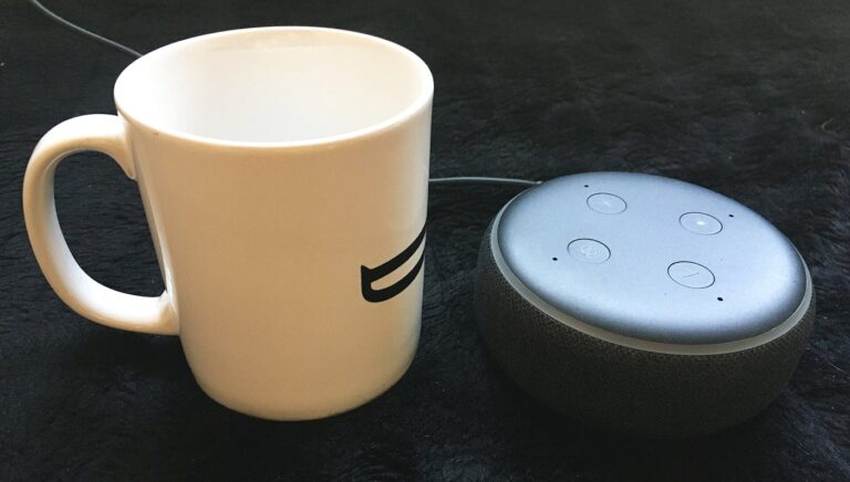 Assistant vocal domestique connecté posé sur une table, symbole de l'IA conversationnelle