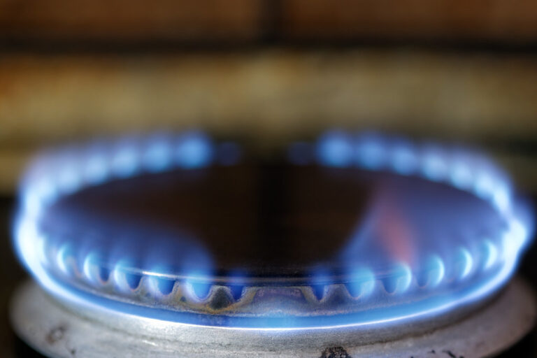 Flamme bleue d'une gazinière allumée en gros plan dans une cuisine