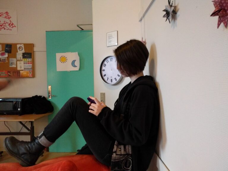Adolescente consultant un smartphone dans sa chambre